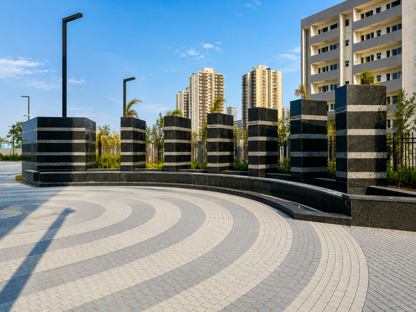 Stone-clad plaza feature with patterned paver hardscape