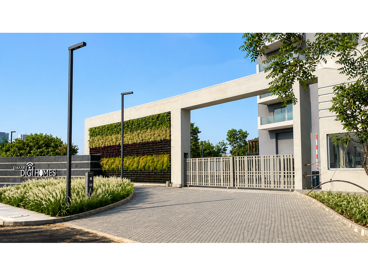 Entrance gateway with green wall and paved driveway at Emaar Digihome